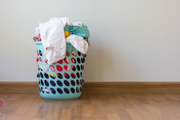 pile of clothes overflow plastic laundry basket for washing preparations