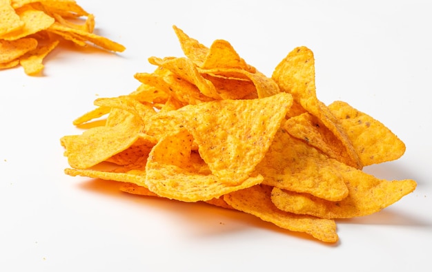 A pile of crispy yellow nachos on a white background