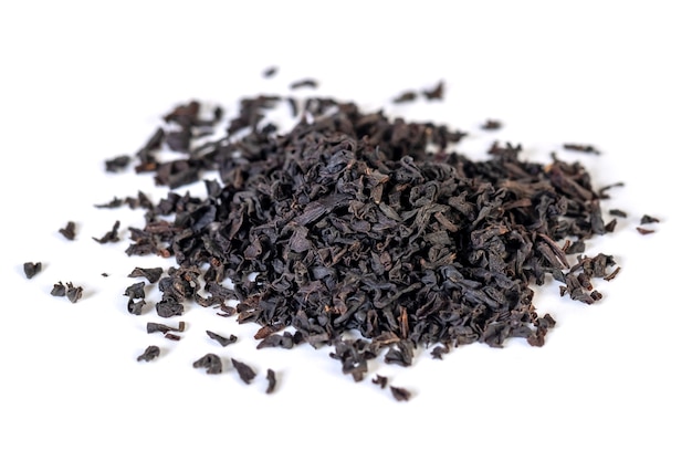 A pile of dried black tea leaves on a white. Energetic drink.