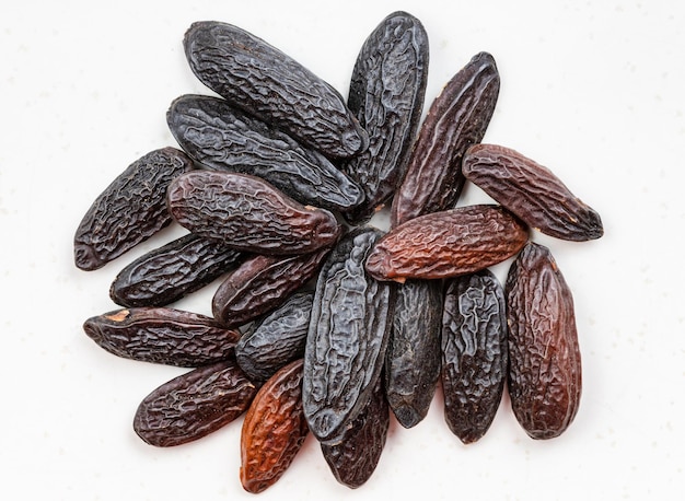 Pile of dried tonka beans close up on gray