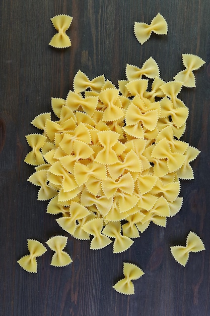 Pile of Farfalle Pasta Also Known As Bowtie Pasta on Black Wooden Background