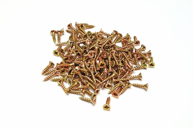 A pile of gold colored screws on a white background