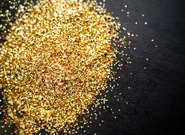 A pile of gold glitters on a black background