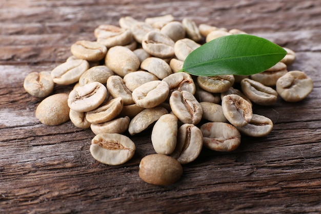 Pile of green coffee beans on wooden table closeup