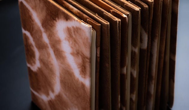 Pile of handmade notebooks isolated against black background