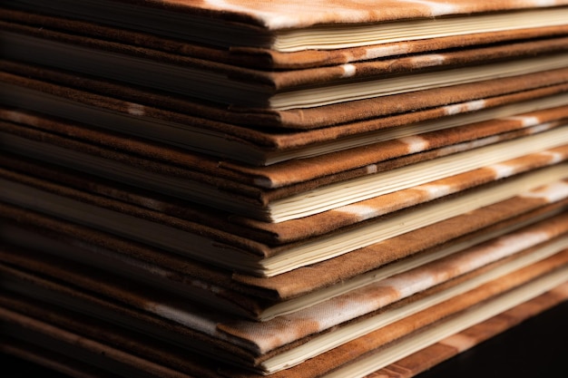 Pile of handmade notebooks isolated against black background