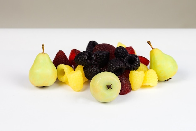 A pile of handmade soap in the shape of berries fruits on a white background