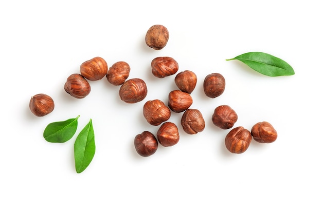 Pile of hazelnuts with leaves isolated on white