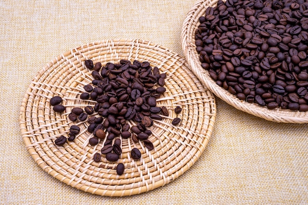 Pile of low quality roasted coffee beans on the rattan tray