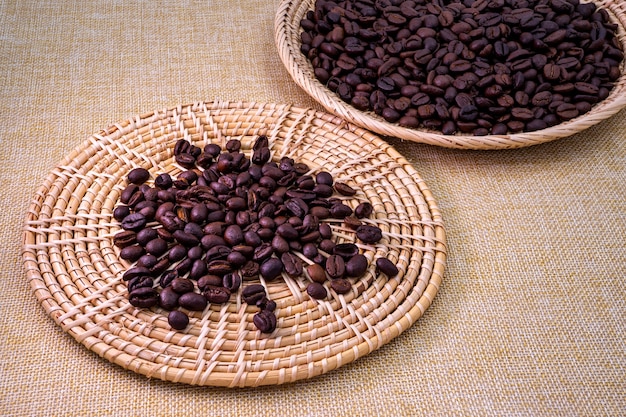 Pile of low quality roasted coffee beans on the rattan tray