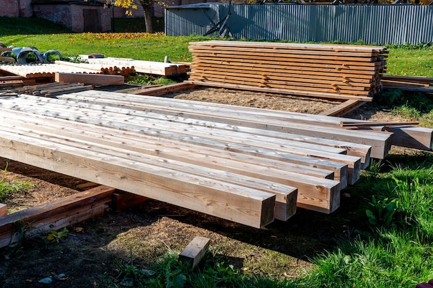 A pile of lumber is being laid out on a pallet.