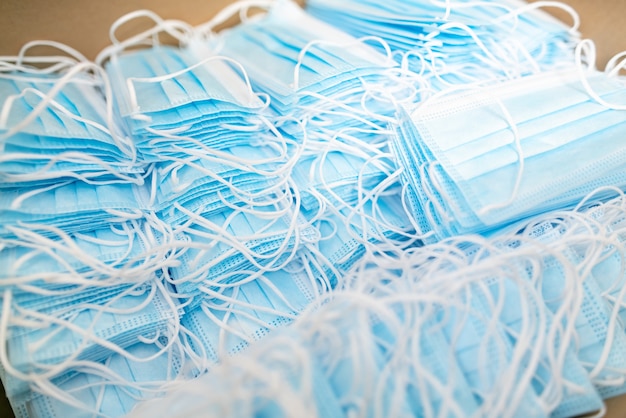 Pile of medical masks stacked and ready for shipping. Close up of blue respiratory face masks.