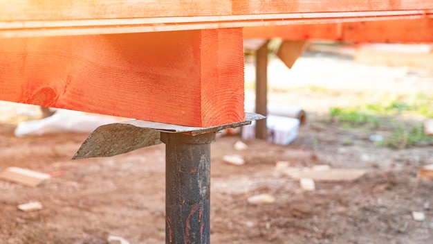 Pile nailed in ground and red wooden beam at foundation premium photo