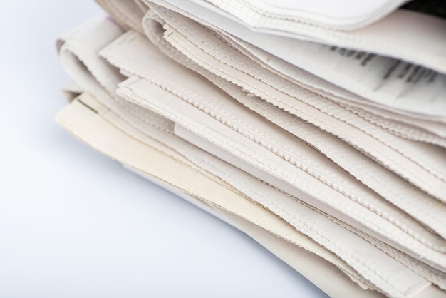 A pile of newspapers on a light background top view