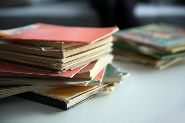 Pile of old books on white table Focus on books and blurred background