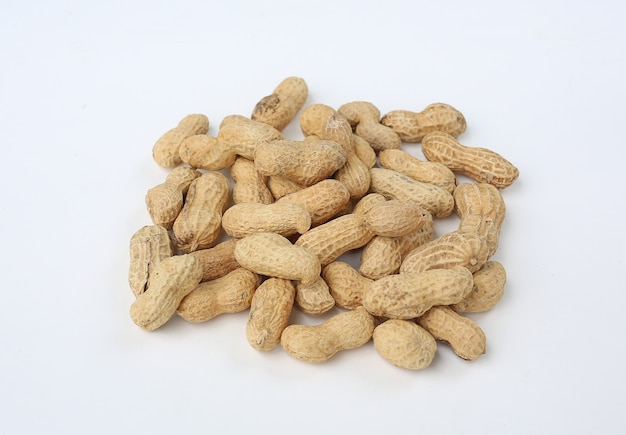 Pile of peanut isolated on white background. Unpeeled nuts.