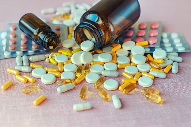 A pile of pills and pills on a pink background