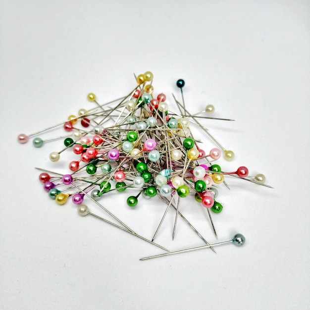 A pile of pins and one of them has a blue and red pin on it.