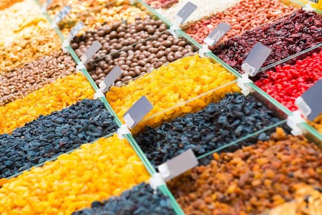 Pile of raisins different kinds of nuts and other organic food on shop counter