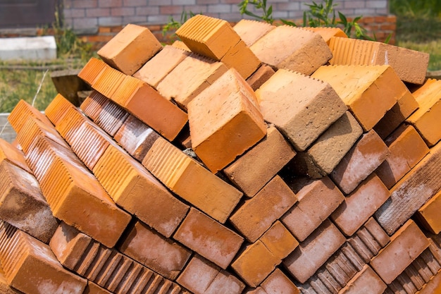 Pile of red bricks close up on the lawn