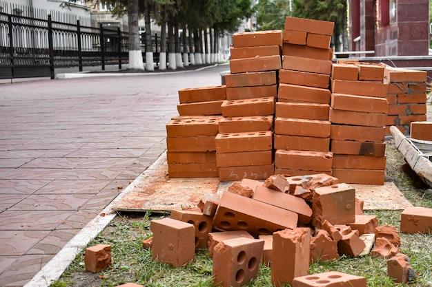 Pile of red bricks at construction site in city. industrial brickwork parts, construction equipment