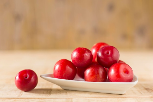 Pile of red plums on the wooden table