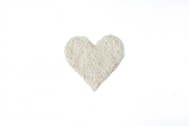 Pile of rice seed in heart shape isolated on white background