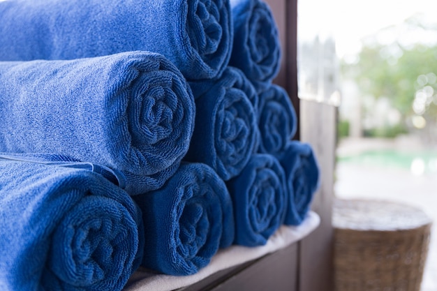 Pile of rolled folded blue towel in spa