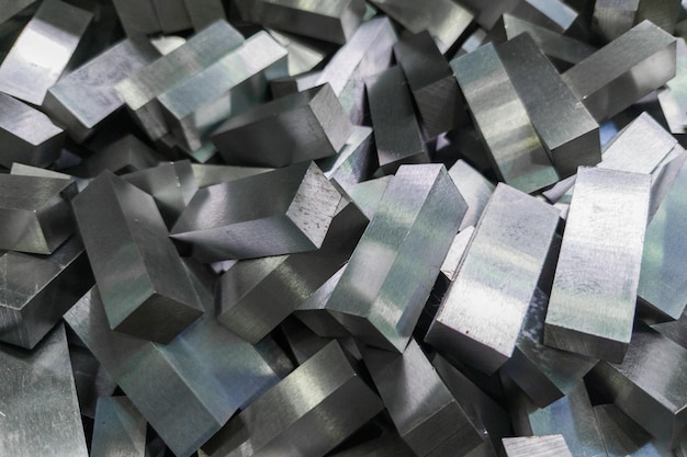 A pile of shiny faceted steel blocks full frame closeup with selective focus