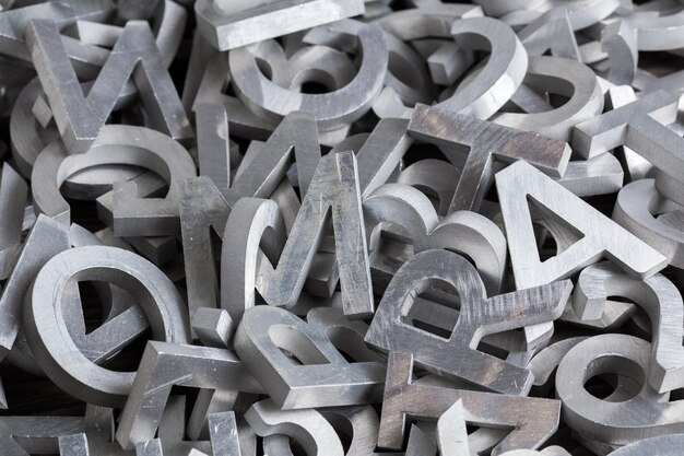 Pile of silver metal alphabet characters cutted by waterjet machine