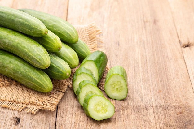 Pile and slice cucumber on wooden table background Food and healthcare concept