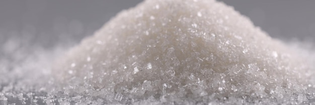 Pile of sugar crystals on grey surface heap of sweet powder to add in dishes