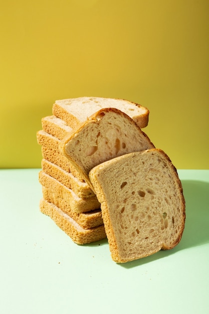 Pile of toast bread on one-ton background in green and yellow