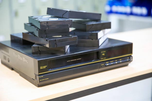 Pile of video cassette tape VHS on video playback stack concept of old retro style or vintage electric and electronic appliances multimedia record player device old fashioned