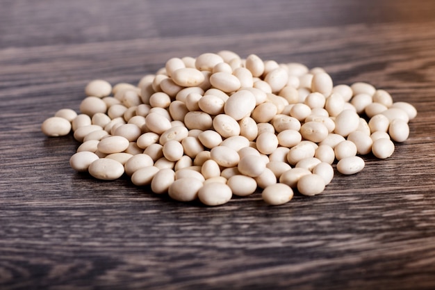 Pile of  white beans isolated on a gray wooden background. 