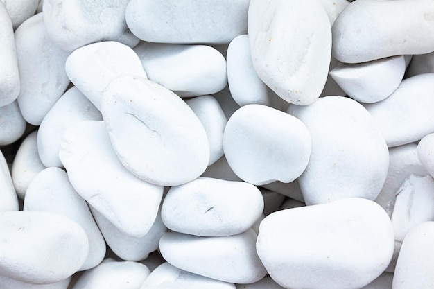 A pile of white smooth decorative stones closeup