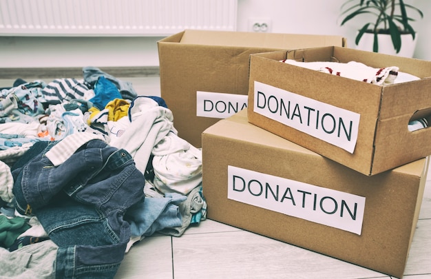 The pile with different kids clothes ready for sorting for donations