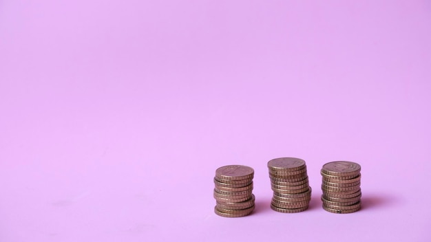 Photo piled coins on pink background with copyspace. economy