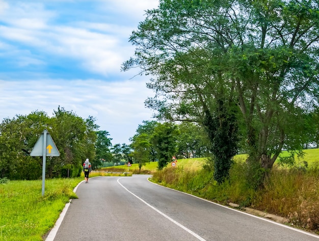 Pilgrim with backpack walking the Camino de Santiago in Spain Way of St James