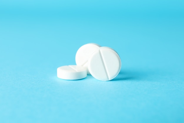 Pills on blue table, closeup