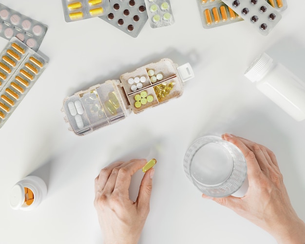 Pills box for daily intake of vitamins and medicines on white background Top view