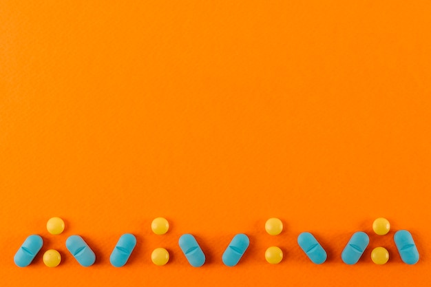 Pills design made on an orange colored backdrop