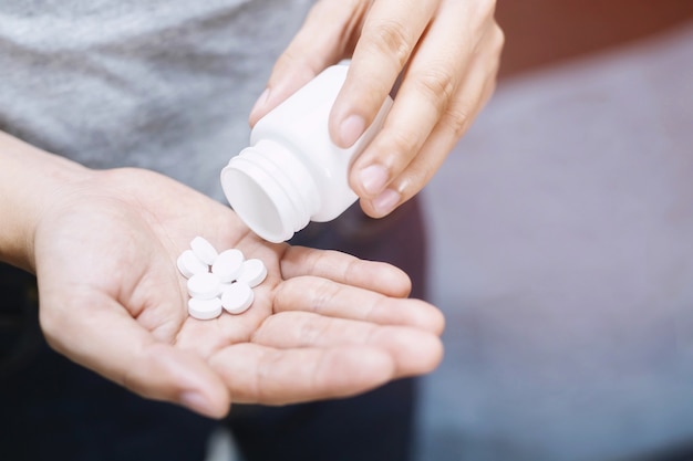 Pills on hand isolated on black background