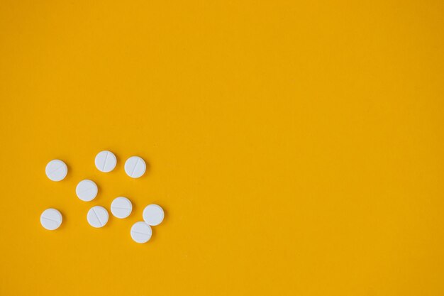 Pills isolated on yellow background