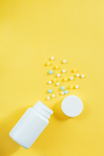 Pills and medicine bottles on a yellow background