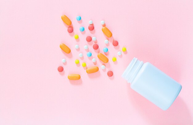 pills and pill bottles on pink background,White pills with selective focus and brown glass bottle