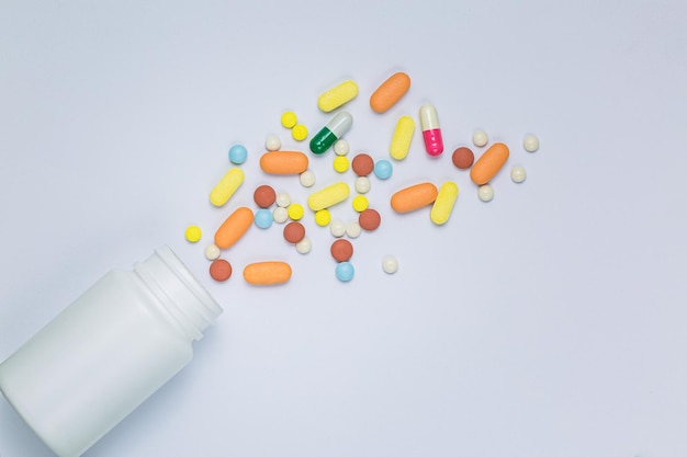 pills and pill bottles on white backgroundFlat lay top view of Various type of pills tablets