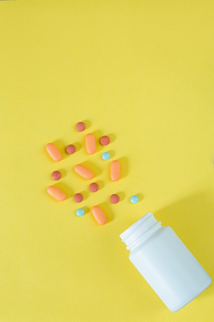 pills and pill bottles on yellow background