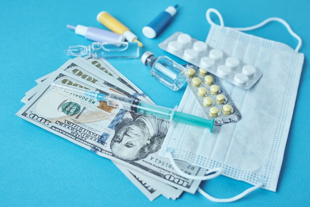 Pills, protective mask, medical items and dollar bills .Expensive medicine concept. Pharmaceutical industry and medical insurance