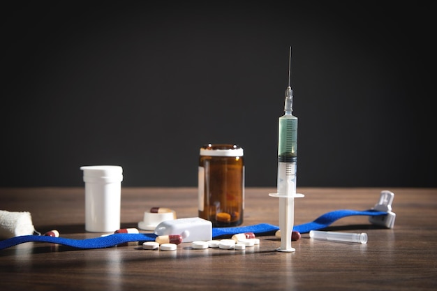 Pills and syringe on the wooden table